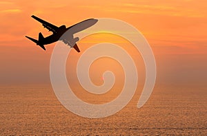 Silhouette passenger airplane flying away in to sky high altitude during sunset time