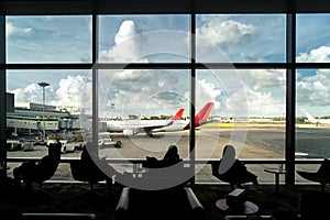 Silhouette of passenger waiting flight for travel in lounge at a