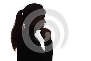 Silhouette of a pensive sad girl with hand under chin , young woman on white isolated background thinking about problem