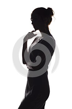 Silhouette of a pensive woman with the hand at the chin on a white isolated background, girl make a decision