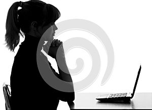 Silhouette of a pensive woman with a laptop