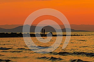 Silhouette of people on the beach against a golden sunset at Lake Turkana, Northern Kenya