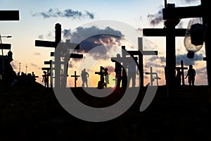 Silhouette of people and crosses fixed on the ground in honor of those killed by covid-19