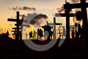 Silhouette of people and crosses fixed on the ground in honor of those killed by covid-19