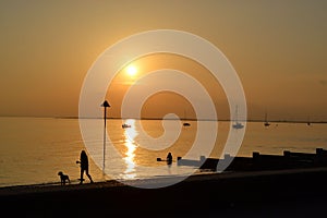Silhouette of people enjoying a peaceful moment on Chalkwell Beach at sunset