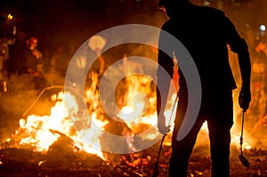 Silhouette of people in front of fire roasting grain for Holi Lohri festival