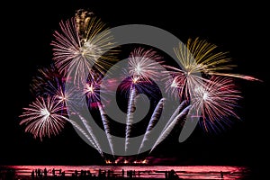 Silhouette people looking beautiful fireworks display on the beach