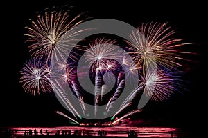 Silhouette people looking beautiful fireworks display on the beach