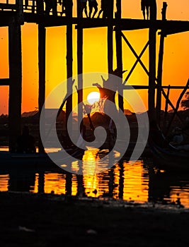 Silhouette of people on U Bein bridge at sunset in Amarapura. Mandalay, Myanmar