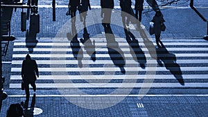 Silhouette people walk on pedestrian crosswalk at the junction