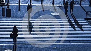 Silhouette people walk on pedestrian crosswalk at the junction s