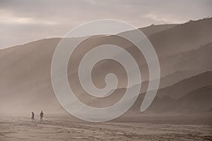 People walking in the far distance on the sandy beach at Brenton on Sea, photographed at sundown. Knysna, South Africa.