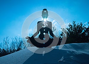 Silhouette of a person doing yoga with the root chakra symbol