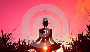 Silhouette of a person doing yoga with the root chakra symbol photo