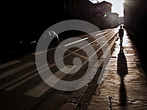 A silhouette of a person in the street with long shadow photo