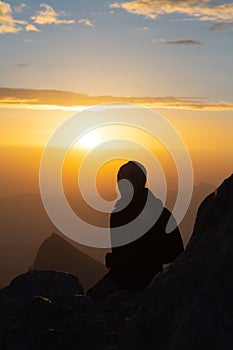 Silhouette of person watching sunrise form top of mountain