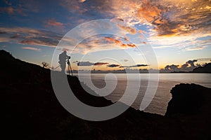 Silhouette of a photographer capturing sunrise