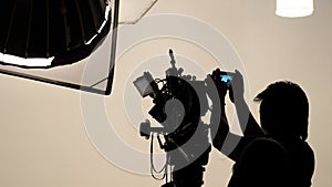 Silhouette of photographer checking for movie camera.