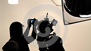 Silhouette of photographer checking for movie camera.