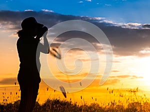Silhouette photographer in grass field