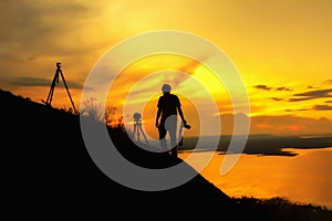 Silhouette photographer on mountain,Photographer shooting sunset,Beauty sunset,Shooting photographer with sunset public landmark.