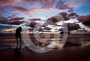 Silhouette photographer shooting image on the beach