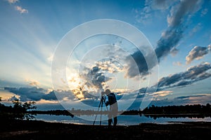 Silhouette photographer on sunset background