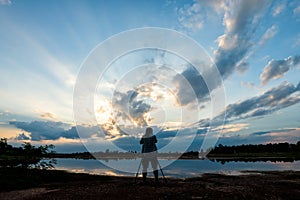 Silhouette photographer on sunset background