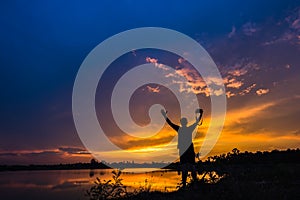 Silhouette photographer at sunset on the lake landscape