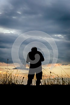 Silhouette of photographer taking pictures of sunset