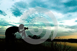 Silhouette of photographer taking pictures of sunset