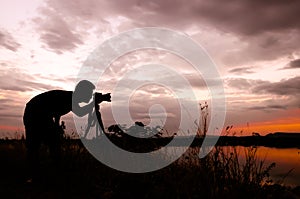 Silhouette of photographer taking pictures of sunset