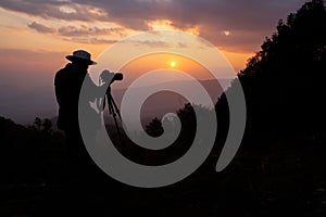 Silhouette of a photographer who shoots a sunset
