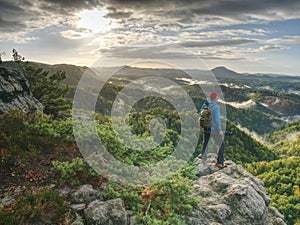 Silhouette of photographer at work during sunset. Photographer or traveller using a professional DSLR camera on a tripod in the