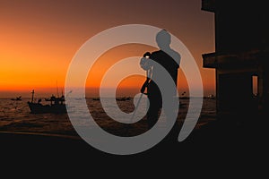 Silhouette of photography man on the beach and sky with beautiful sunset.