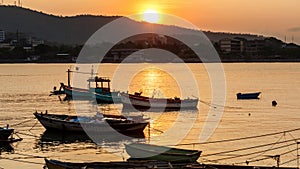 Silhouette of pier boat with the sun setting in background, cloudy and colorful sky