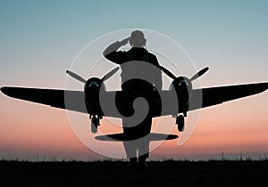 Silhouette of Pilot Saluting in Front of Airplane at Sunset