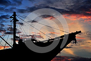 Silhouette of pinisi ship with sunset sky