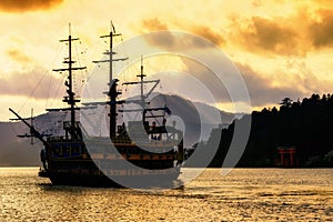 Silhouette Pirate ship an torii gate at lake Ashi