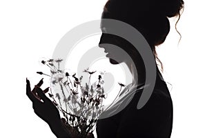 Silhouette portrait of a beautiful girl with a bouquet of dandelions, face woman profile on a white isolated background