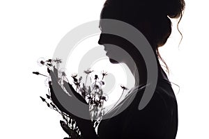 Silhouette portrait of a girl with a bouquet of dry flowers, face profile of a dreamy young woman on a white isolated background