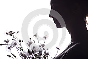 Silhouette portrait of a girl with a bouquet of dry flowers, face profile of a dreamy young woman on a white isolated background