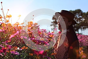 Silhouette portrait lady in flower field at sunrise,caucasian woman with pink cosmos flowers