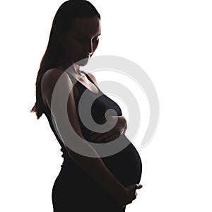 Silhouette portrait of pregnant woman in black dress on white background