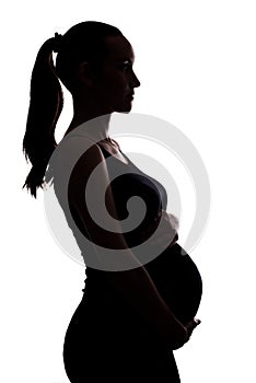 Silhouette portrait of pregnant woman on white background with hands on belly