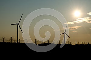 Silhouette of Power Lines and Wind Turbines Near Sunset