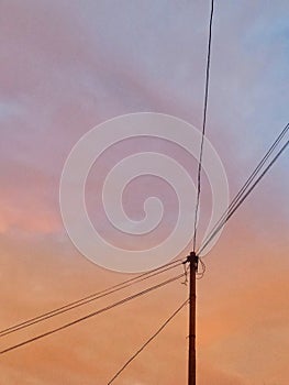 Silhouette of the power pole on orange skies