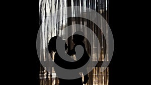 Silhouette of pregnant mother and six months old baby - mother lifting kissing and spining little baby