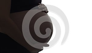 Silhouette of pregnant woman`s belly with hands touching it on white isolated background, new life concept
