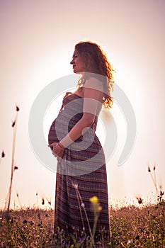 Silhouette of a pregnant woman at sunset